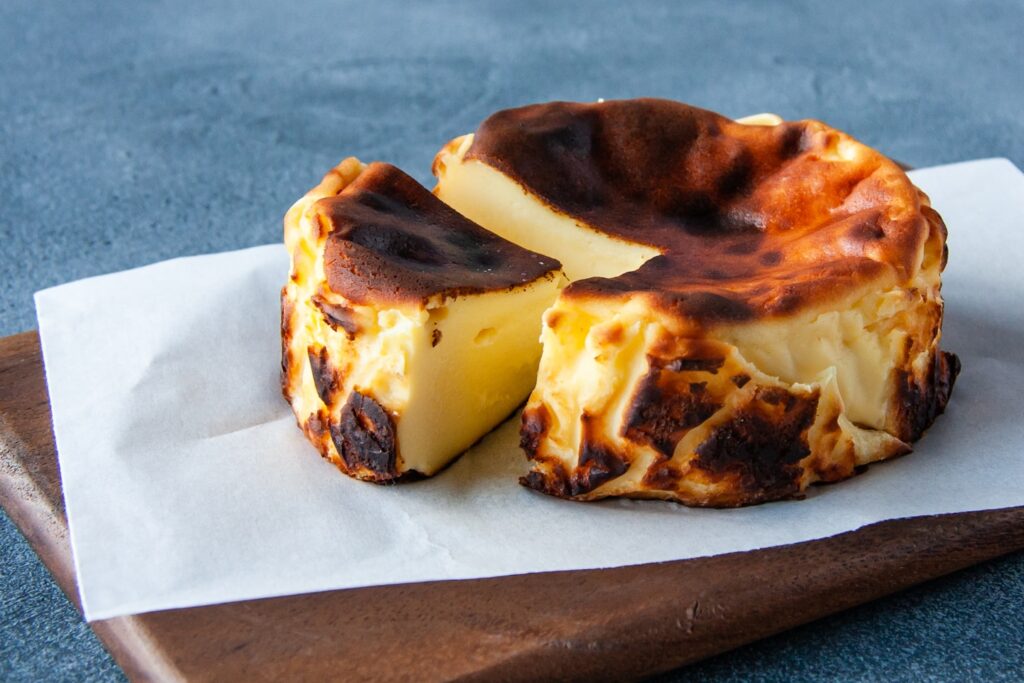 a cheesecake on a wooden cutting board with a knife